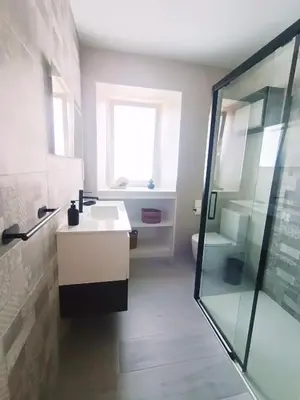 a bathroom with a sink and a shower and a toilet at Casa da Americana II in Boqueijón