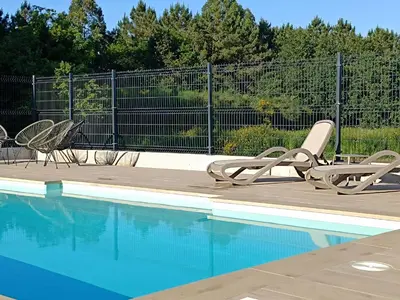 a pool with two lounge chairs next to a fence at Casa da Americana II in Boqueijón
