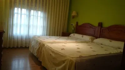 a bedroom with two beds and a window at Tierra De Lobos in Puebla de Sanabria