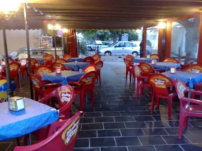 a restaurant with tables and red chairs and a car at Tierra De Lobos in Puebla de Sanabria