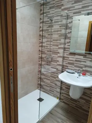 a bathroom with a sink and a glass shower at Lazzaretto vivienda uso turístico in Lugo