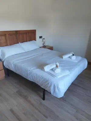 a large bed with white sheets and towels on it at Lazzaretto vivienda uso turístico in Lugo
