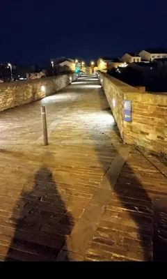 a shadow of a person on a boardwalk at night at Lazzaretto vivienda uso turístico in Lugo