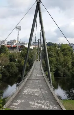 a suspension bridge over a river at Lazzaretto vivienda uso turístico in Lugo