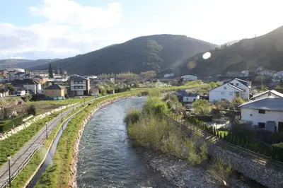 a river in a town with houses and mountains at Venecia Bed&Breakfast in Villafranca del Bierzo
