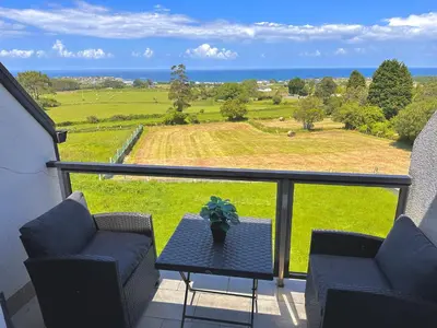 a balcony with a table and chairs and a view of a field at Arnela Reinante in Barreiros