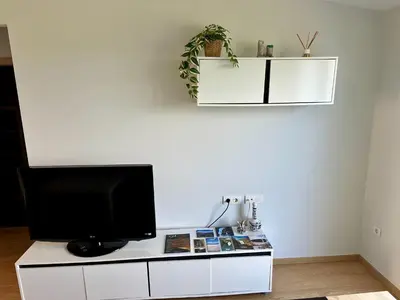 a living room with a television on a white cabinet at Arnela Reinante in Barreiros