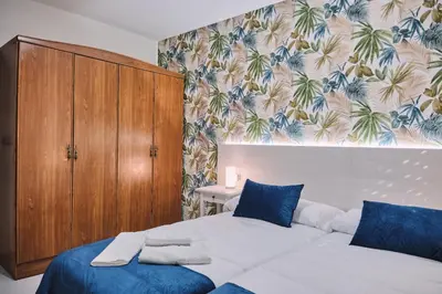 a bedroom with a large bed and a wooden cabinet at Peregrina Pensión 6 in O Pedrouzo