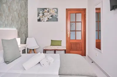 a bedroom with a white bed and a wooden door at Peregrina Pensión 6 in O Pedrouzo