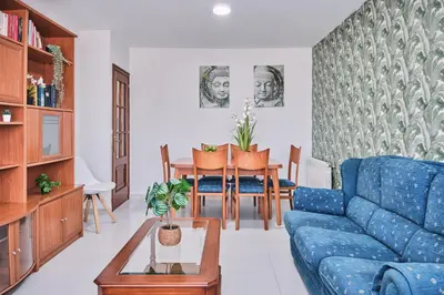 a living room with a blue couch and a table at Peregrina Pensión 6 in O Pedrouzo