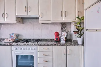 a kitchen with white cabinets and a stove top oven at Peregrina Pensión 6 in O Pedrouzo