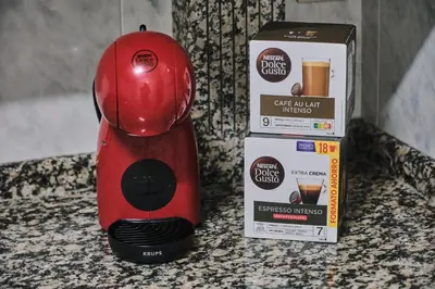 a red coffee maker sitting on a counter next to a box at Peregrina Pensión 6 in O Pedrouzo