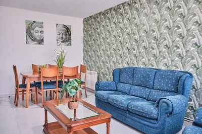 a living room with a blue couch and a table at Peregrina Pensión 6 in O Pedrouzo