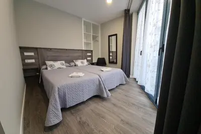 a bedroom with a bed with two towels on it at Apartamentos Carballal in Palas de Rei