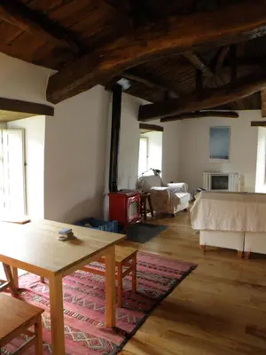 a living room with a table and a couch at Casa de las Flores / Casa de campo LUGO in A Pontenova