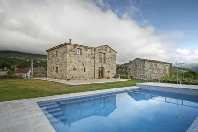 a stone house with a swimming pool in front of it at A Casa da Tulla in Gomesende