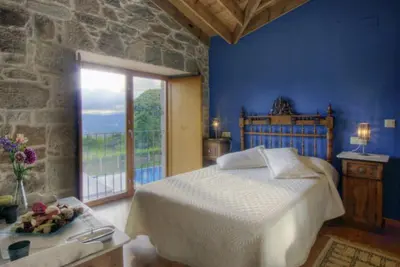 a bedroom with a bed and a large window at A Casa da Tulla in Gomesende