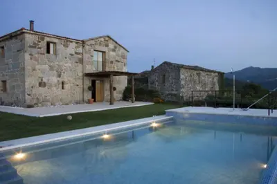 a stone house with a swimming pool in front of it at A Casa da Tulla in Gomesende