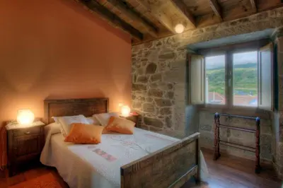 a bedroom with a bed with two lamps and a window at A Casa da Tulla in Gomesende