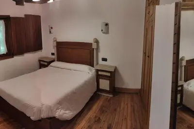 a bedroom with a large bed and wooden floors at Casa Vilanova in A Coruña