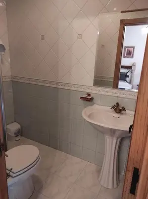 a bathroom with a sink and a toilet and a mirror at Casa Vilanova in A Coruña