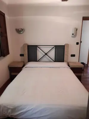 a large white bed in a bedroom with two chairs at Casa Vilanova in A Coruña