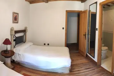 a bedroom with a white bed and a mirror at Casa Vilanova in A Coruña