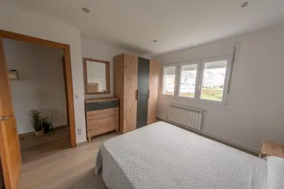 a bedroom with a white bed and a window at Piso en el puerto con vistas al Mar+Wifi+ SmartTv in Burela de Cabo