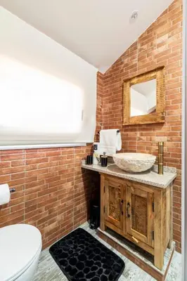 a bathroom with a sink and a brick wall at Casa Rústica O Abeiro in Pontevedra