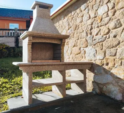 a stone oven sitting next to a stone wall at Casa Rústica O Abeiro in Pontevedra