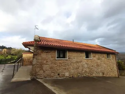 a stone building with a red roof at Casa Rústica O Abeiro in Pontevedra