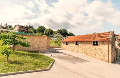a stone building with a red roof at Casa Rústica O Abeiro in Pontevedra