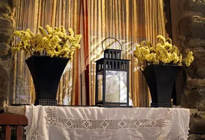 two black vases with yellow flowers on a table at Albergue San Lázaro in Sarria