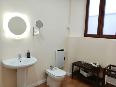 a bathroom with a sink and a toilet and a mirror at Albergue San Lázaro in Sarria