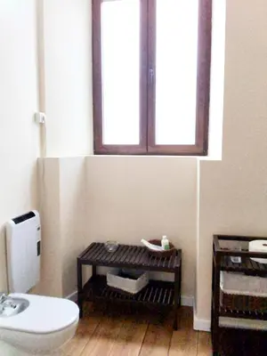 a bathroom with a toilet and a window at Albergue San Lázaro in Sarria