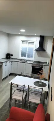 a kitchen with a white table and chairs and a counter at RECUNCHIÑO in San Xoán de Río