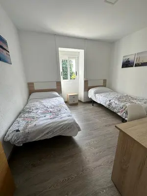 a bedroom with two beds and a window at RECUNCHIÑO in San Xoán de Río