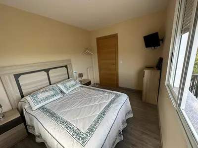 a bedroom with a large bed and a window at RECUNCHIÑO in San Xoán de Río