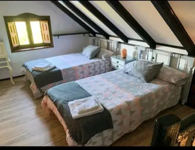 a bedroom with two beds and a window at Casa do Duende in Tedejo