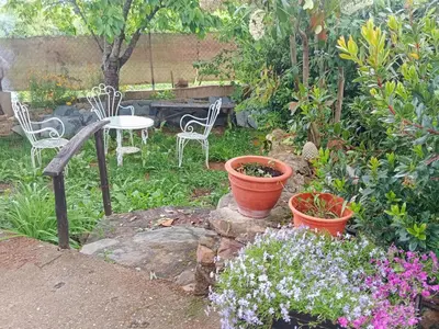 a garden with two pots and chairs and flowers at Casa do Duende in Tedejo