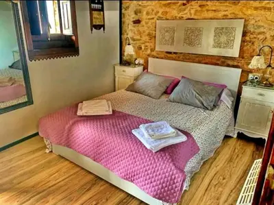 a bedroom with a bed with pink sheets and a mirror at Casa do Duende in Tedejo