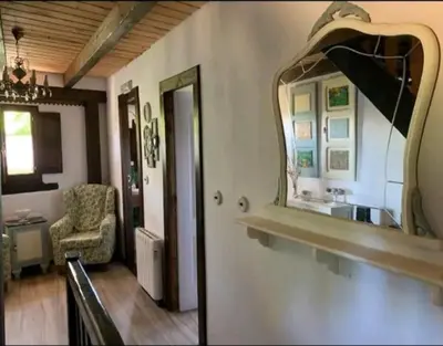 a bathroom with a mirror and a chair in a room at Casa do Duende in Tedejo