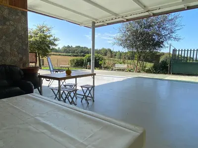 a patio with a table and chairs under a pavilion at Casa da Pinguela Camino Inglés in Ordes