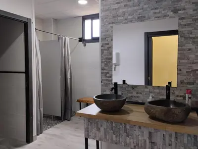 two sinks on a counter in a bathroom with a mirror at Hostel Azul Cielo in O Pedrouzo