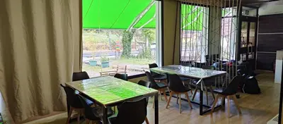 a room with two tables and chairs and a window at Hostel Azul Cielo in O Pedrouzo