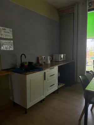 a kitchen with a white counter top and a table at Hostel Azul Cielo in O Pedrouzo