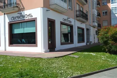 a building with two windows and a tree in front of it at Albergue Credencial in Sarria