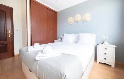 a white bedroom with two towels on a bed at Apartamento Las Candelas, Ares in Ares