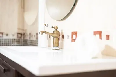 a bathroom sink with a gold faucet and a mirror at Apartamento Las Candelas, Ares in Ares