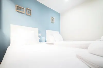 two white beds in a room with blue walls at Apartamento Las Candelas, Ares in Ares